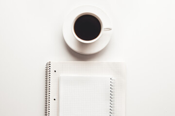 Office desk table with supplies, coffee cup and flower. Top view