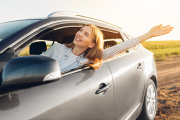 Close up portrait of young woman, content with travel by car, sitting on driver's seat