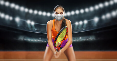 sportswoman holding tennis racket in protective breathing mask and looking at camera - COVID CONCEPT