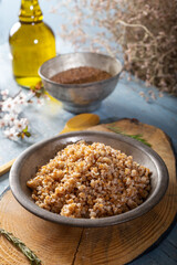 Einkorn, Triticum Monococcum, Siyez wheat bulgur.Bulgur pilaf made with siyez bulgur in plate on wooden background.