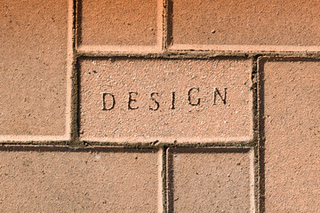 The word design stamped in the surface of brick paving a building and construction concept