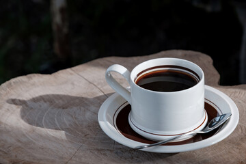 morning black coffee on wooden table in sunshine