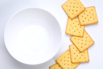 top view shot of crackers  on white table with empty cup