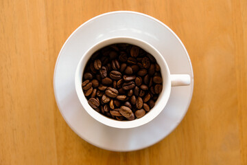 coffee beans in cup coffee on table wood background