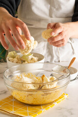 Making cauliflower nuggets: bowl full of vegan milk and gluten free bread and cutted cauliflower
