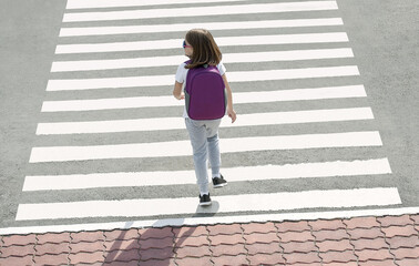 Stylish young teen girl walking with backpack. Active child. Kid runs across the crosswalk. Way forward. Direction to success. Positive thinking. Symbol of overcome obstacles and challenge. Top view