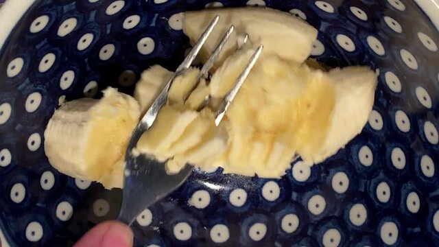 Banane mit einer Gabel mu&szlig;en, zerdr&uuml;cken f&uuml;r gesundes M&uuml;sli als nat&uuml;rliche S&uuml;&szlig;e