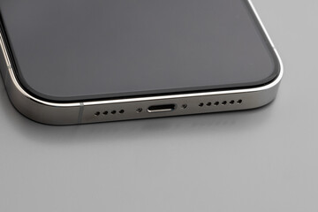 Close up of charging port of modern smartphone on gray background