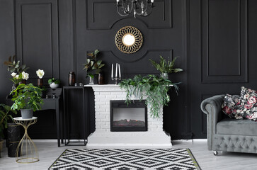 luxury interior decor black wall with white brick fireplace, gold frame and gray sofa. classic...