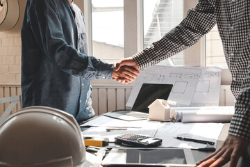 Architect man shaking hands with Customer to build home success at the office.