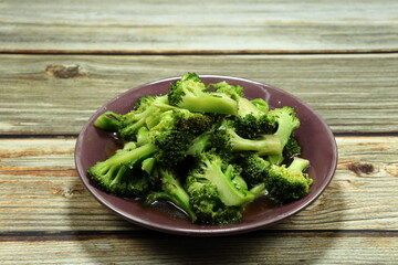 Traditional fried and stirred fresh broccoli seasoning with soy sauce and pepper serving on the plate. Famous vegetarian menu in Asia restaurant. 