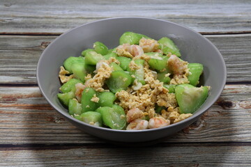 Traditional fried and stirred cutting Chinese zucchini mixed with egg and peeled shrimp serving on the plate. 