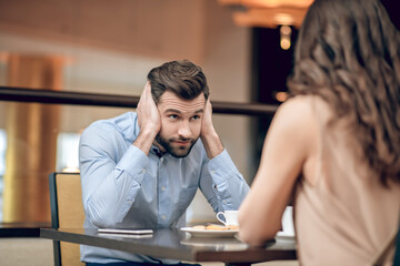 Man and woman having a blind date and looking disappointed