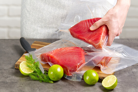 A Cook Or A Seller At A Fish Market Holding A Bluefin Tuna Steak Packed In A Vacuum Bag