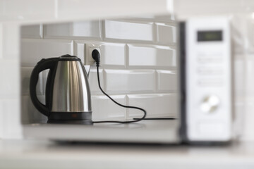 reflection of the electric kettle in the microwave door