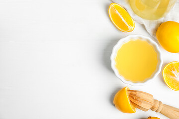 Freshly squeezed lemon juice on white wooden table, flat lay. Space for text