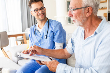 Fototapeta premium Male nurse talking to seniors patients while being in a home visit.