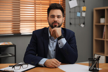 Portrait of young businessman at desk in office