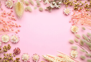 Frame of beautiful dried flowers on light pink background, flat lay. Space for text