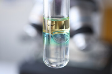 Closeup of glass test tube with yellow and green liquid