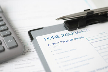 Home insurance documents and ballpoint pen lying on desktop closeup