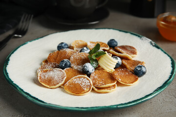 Cereal pancakes with blueberries and butter on grey table
