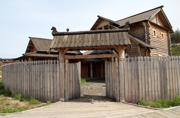 Fototapeta na wymiar Old vintage wooden houses and citadel, ancient architecture of Kiev, park Kyivan Rus, Ukraine