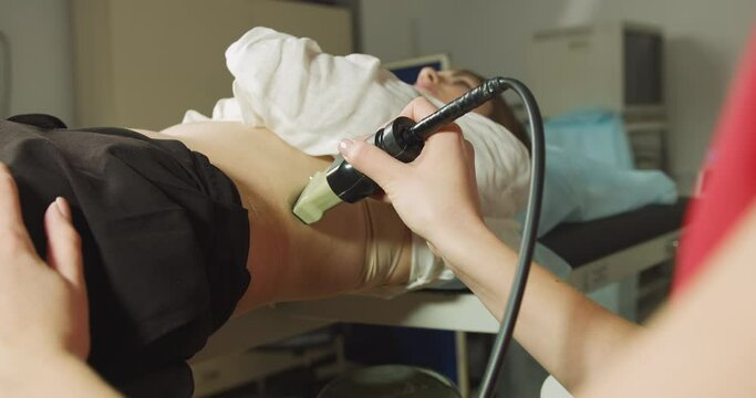 Extracorporeal shockwave therapy in urology. Cropped shot of lying woman patient, having ultrasound to determine kidney stones position before the lithotripsy procedure.
