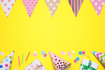 Flat lay composition with party decor on yellow background. Space for text