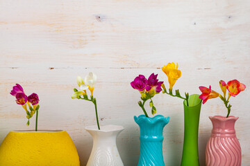 Freesias in multi-colored vases