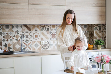 Smiling mother takes selfie with cute daughter on tablet, happy young mom laughing makes photo with daughter at home, single mom and adopted children playing fun with phone