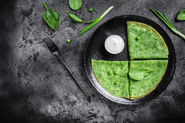 Spinach green pancakes crepes with sour cream. Delicious healthy Breakfast. banner, menu recipe place for text, top view