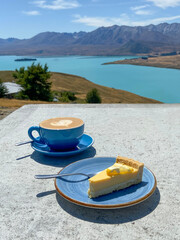 Tasse Cappuccino und Teller mit Zitronentarte vor Lake ⁨Tekapo⁩, ⁨Canterbury⁩,...