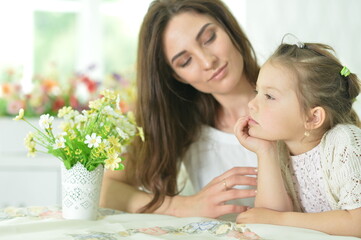 Close-up portrait of a charming little girl with mom at home