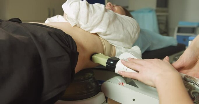 Extracorporeal shockwave therapy in urology. Cropped shot of lying woman patient, having ultrasound to determine kidney stones position before the lithotripsy procedure.