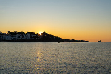 Naklejka premium Marvelous sunrise at beautiful costal town Cadaques at Catalonia, Spain. Cosy houses on the Mediterranean sea light by the rising sun with the soft warm light. Serenity and off season vacation. 
