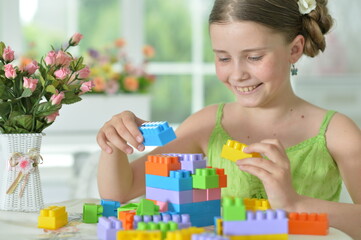  girl playing with colorful plastic blocks