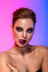 High Fashion model multicolor lips and face woman in colorful bright neon uv blue and purple lights, posing in studio, beautiful girl, glowing make-up, colorful make up. Glitter Vivid neon makeup