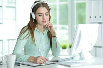 Portrait of  businesswoman working in headphones  in office