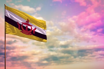 Fluttering Brunei Darussalam flag mockup with the space for your content on colorful cloudy sky background.