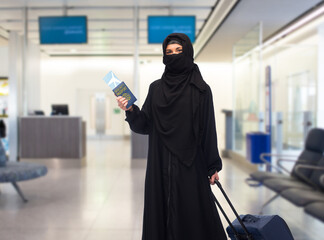 muslim woman with ticket, immune passport and bag