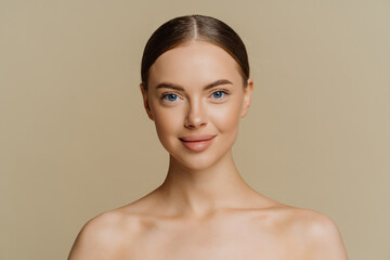 Indoor shot of beautiful young woman with combed hair stands half naked indoor has natural beauty...
