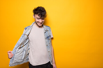 Junger Mann posiert vor einem gelben Hintergrund