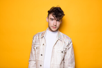 Junger Mann posiert vor einem gelben Hintergrund