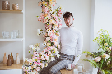 Junger Mann posiert mit Blumenranke