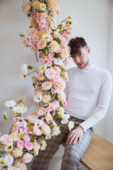 Junger Mann posiert mit Blumenranke