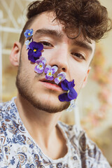 Junger Mann mit Blumenranke im Gesicht