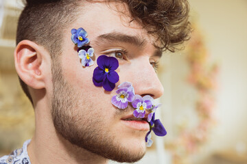 Junger Mann mit Blumenranke im Gesicht