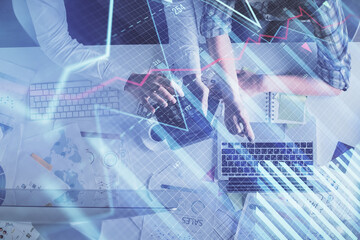 Double exposure of man and woman working together and financial graph hologram drawing. market analysis concept. Computer background. Top View.