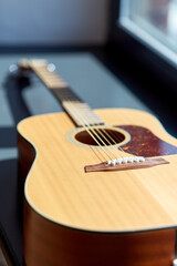 Fototapeta premium close up of acoustic guitar on window sill